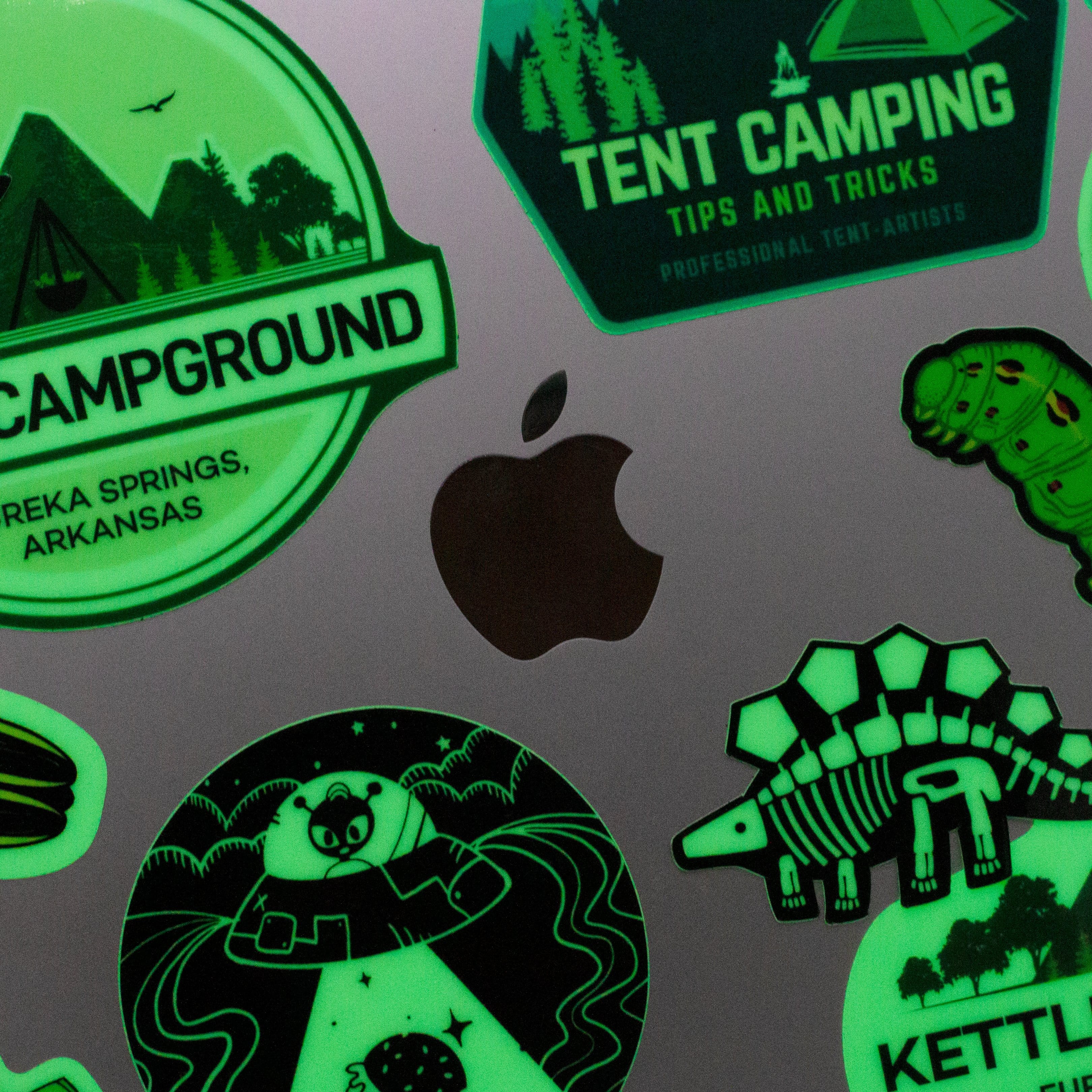 Custom glow in the dark stickers for a campground image of tents caterpillar stegasaurous skeleton flying saucers text. Tips and tricks. professional tent-artists. Eureka Springs. Arkansas. kettle