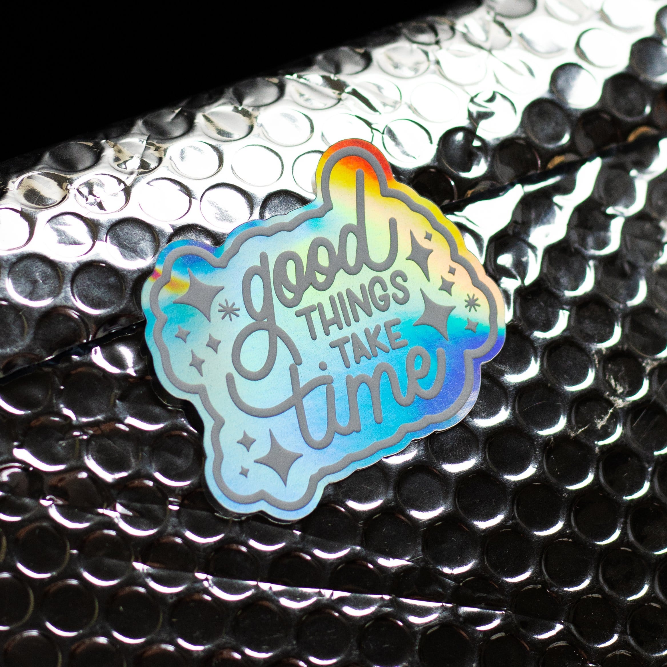 Good Things Take Time custom holographic sticker. White text reads. Good things take time. 