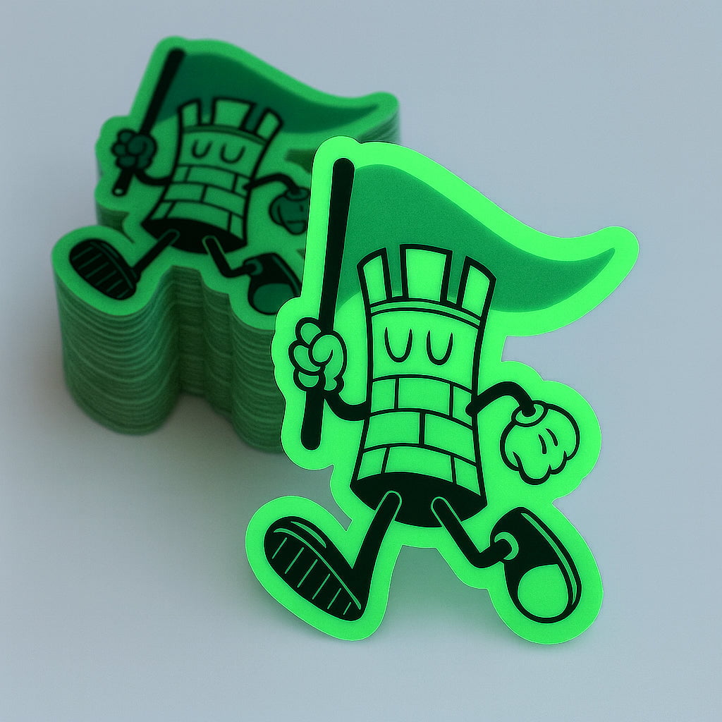 Stack of green superhero-themed Glow in the dark stickers black and green on gray low light background 