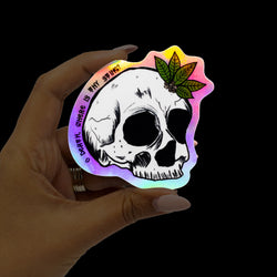 Custom holographic illustrated sticker of skull with plant growing from it with text. Death where is thy sting. 