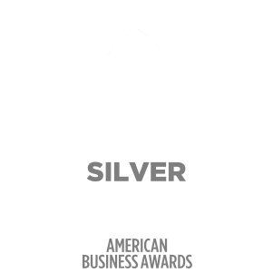 Silver Stevie Winner badge from American Business Awards 2023 with a white silhouette of a person holding a trophy against a green background.